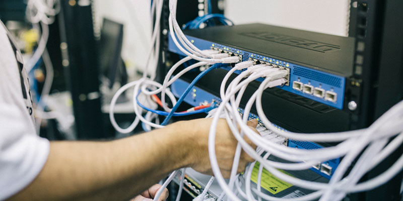 computer networking technician inspecting wires and cables