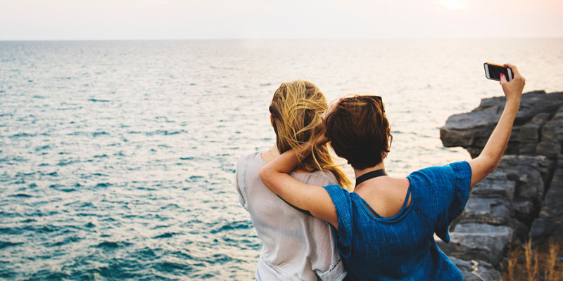 women taking selfie by ocean