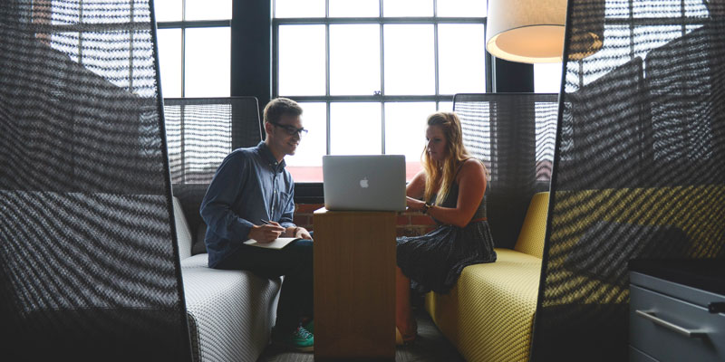 two collaborative people in casual meeting using laptop