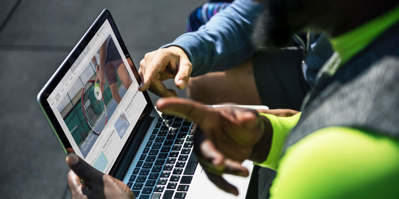 two people on laptop analyzing website outdoors