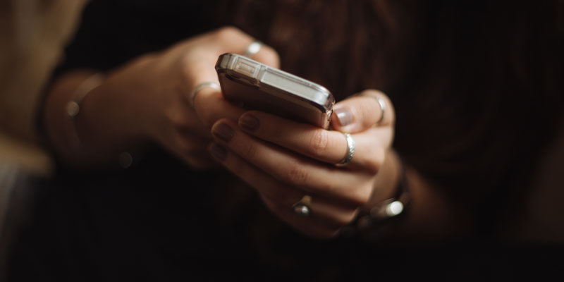 woman's hands holding smartphone