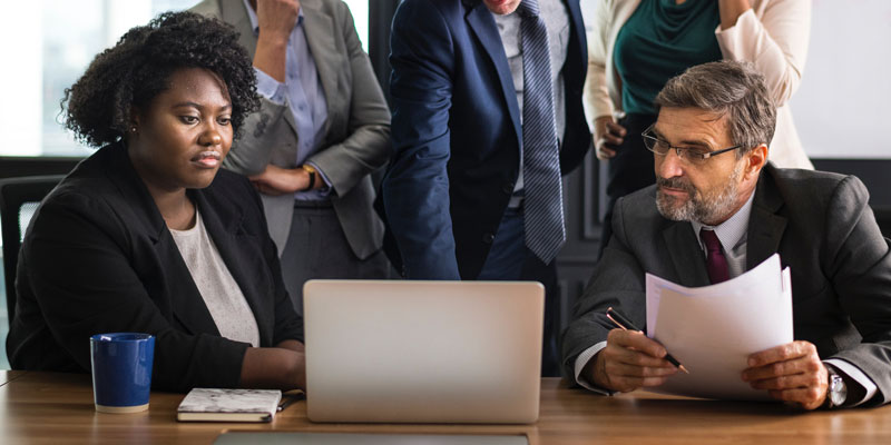 5-person team looking at 1 laptop