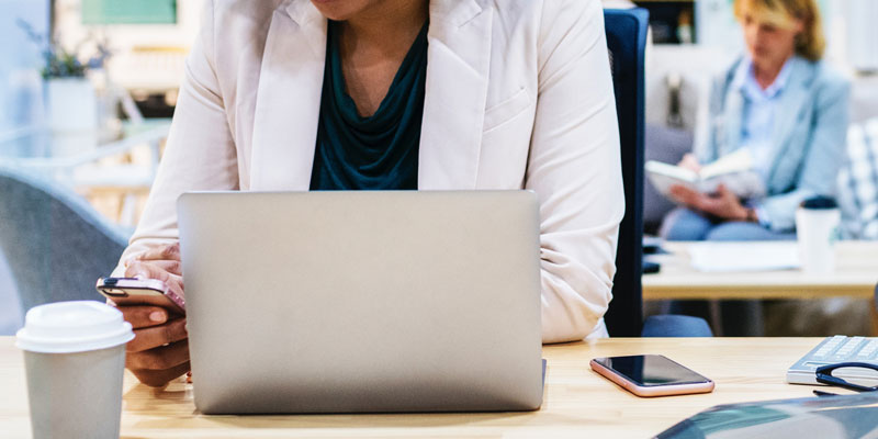 businesswoman on phone and laptop at desk