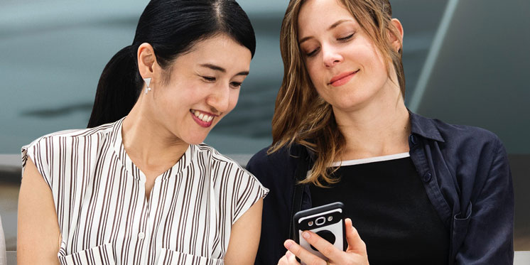 two women looking at a phone